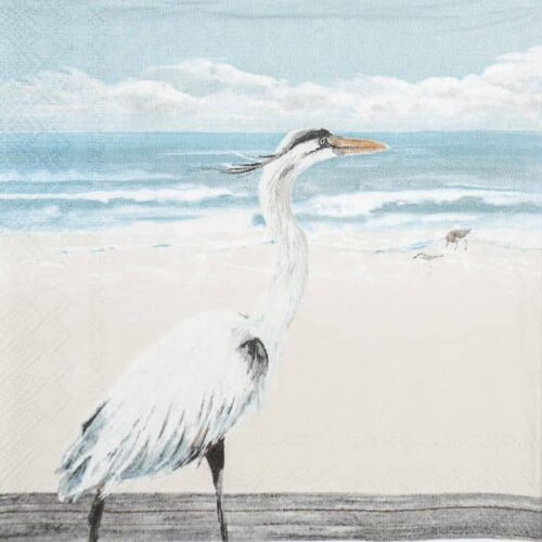 Close-up of a paper napkin showing a white egret standing on sandy beach with soft blue sea and sky background