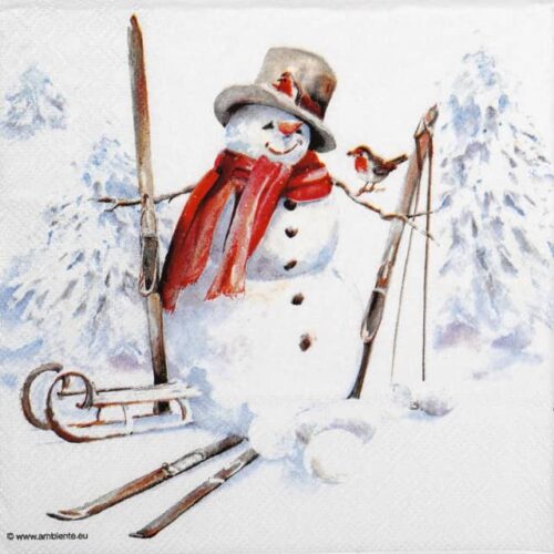 Festive winter-themed decoupage napkin featuring a cheerful snowman wearing a red scarf and top hat, surrounded by skis and a sled, with a small robin perched on its arm, against a snowy pine forest backdrop. Quarter of the napkin.
