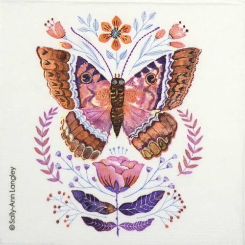 Close-up of a stylized butterfly or moth with shades of brown, pink, and cream wings and floral-accent toppers on a pale background